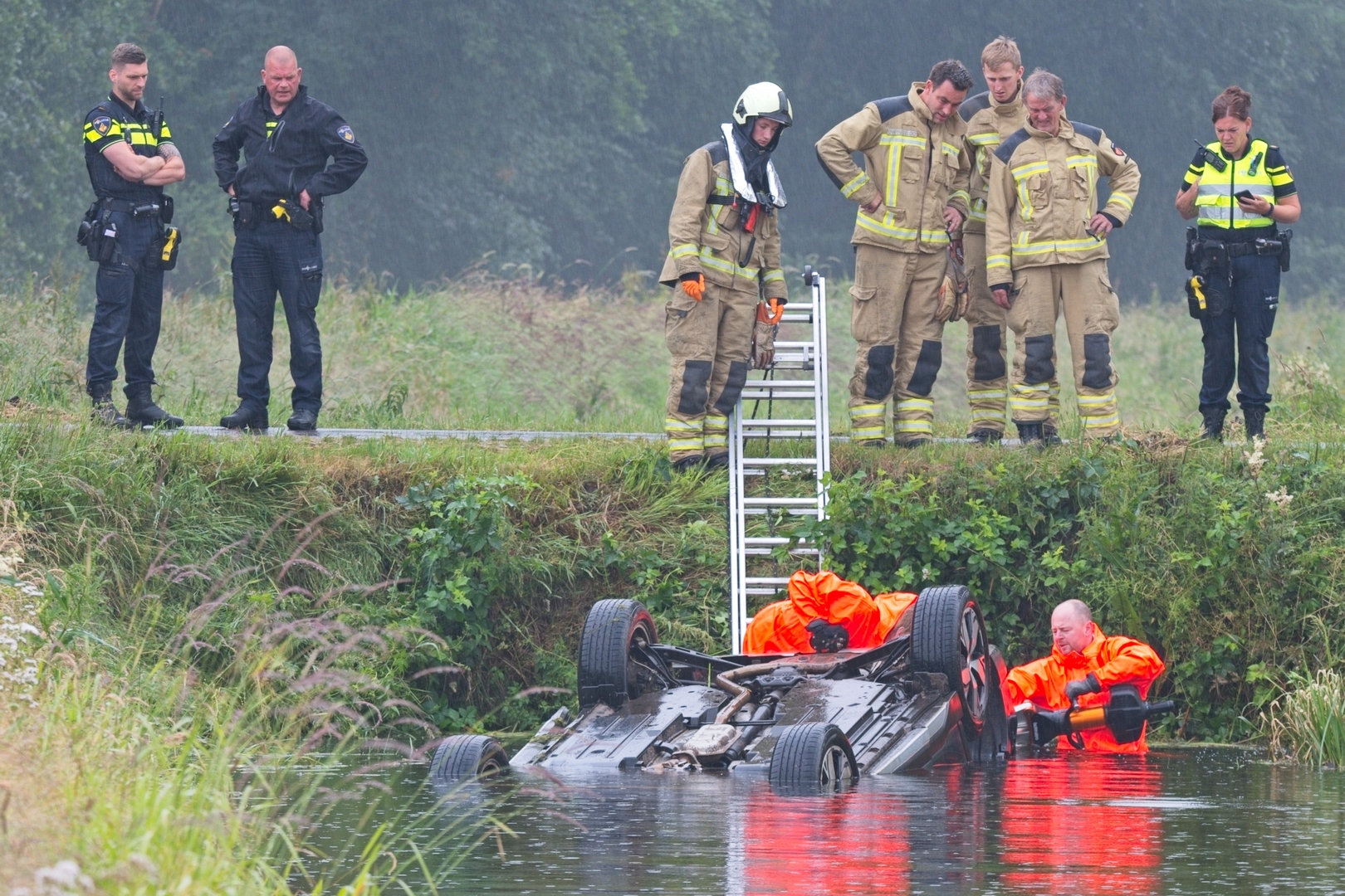 Auto op de kop in het water in Wittelte